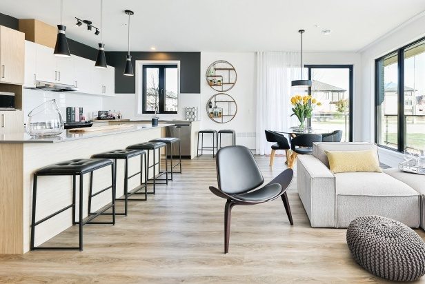 Cuisine et salon d'un condo Opéra : îlot avec tabourets noirs, plancher de bois clair, grandes fenêtres